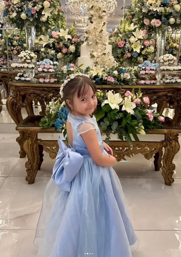 Criança usando vestido azul personalizado em festa